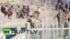Spain: Dozens of migrants straddle border fence in Melilla
